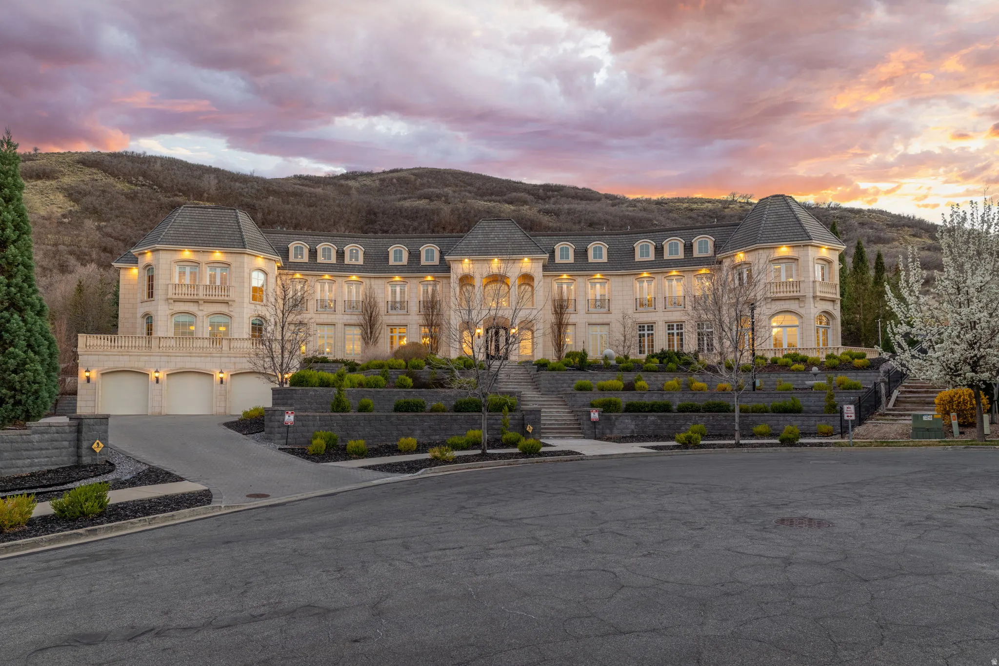 Property at dusk with driveway and an attached garage