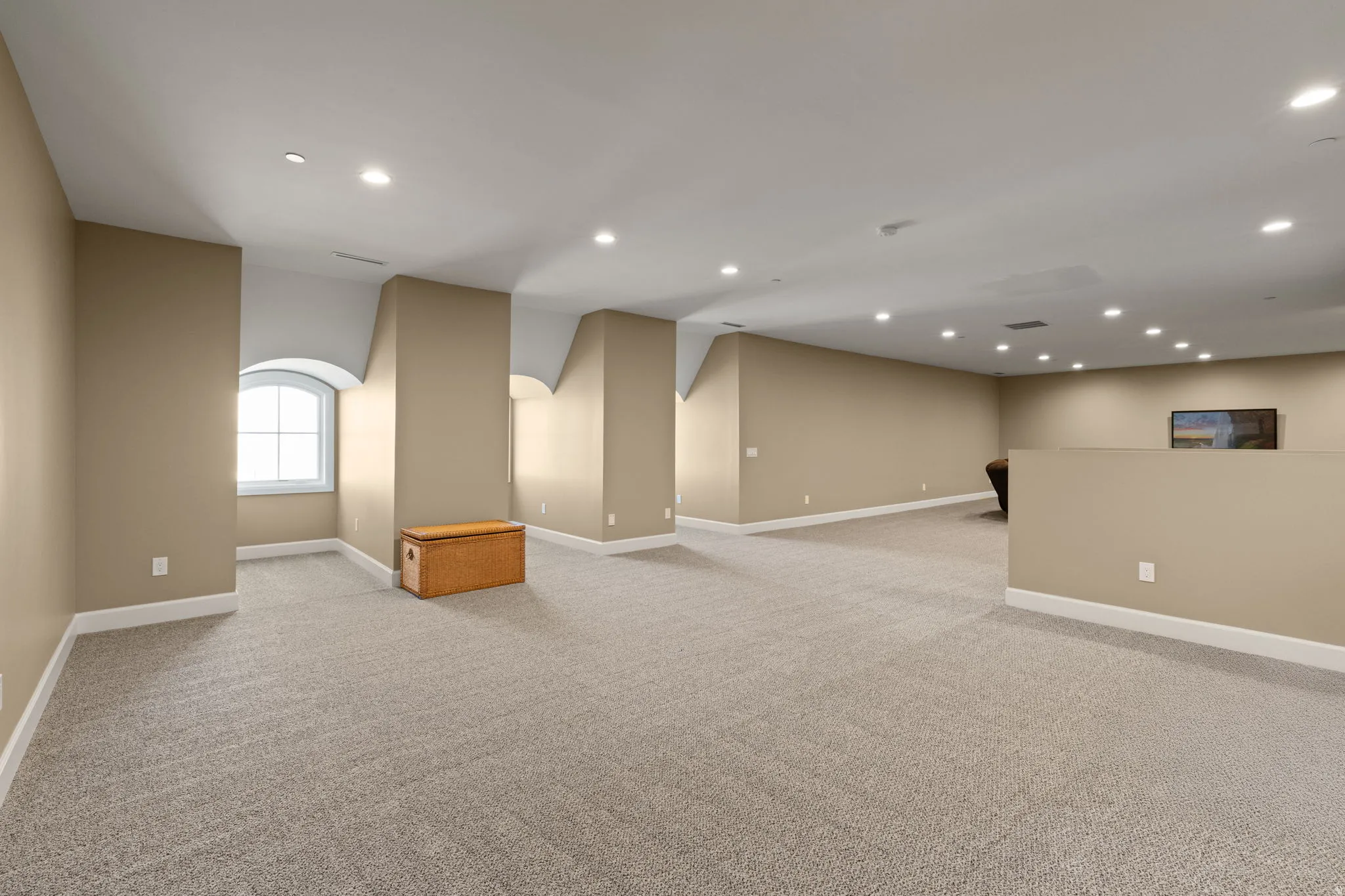 Empty room with light carpet and recessed lighting