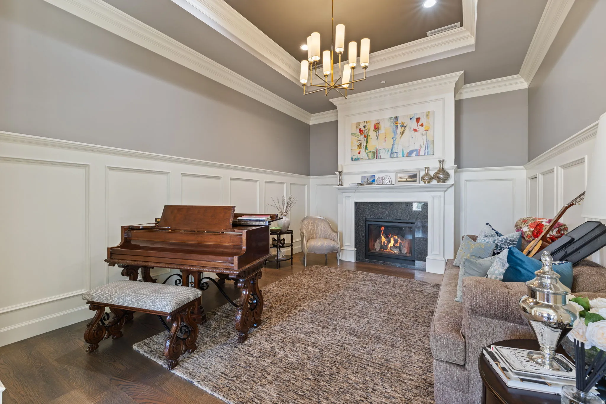 Sitting room featuring a decorative wall, wainscoting, dark wood-type flooring, a premium fireplace, and a chandelier