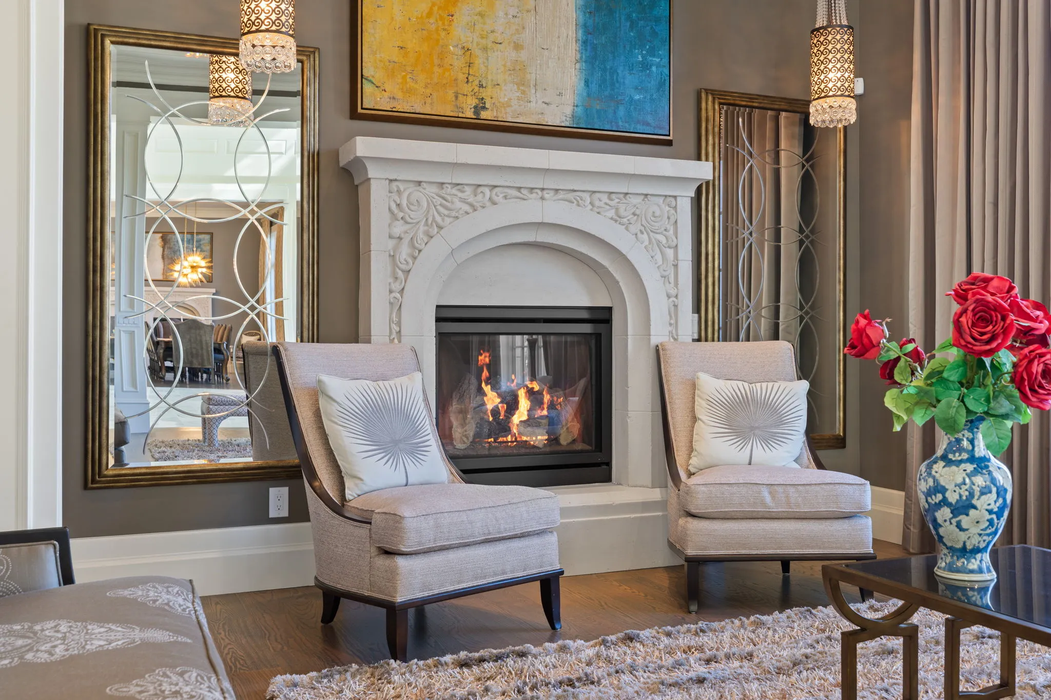 Sitting room with suspended lighting, a multi sided fireplace, and wood finished floors