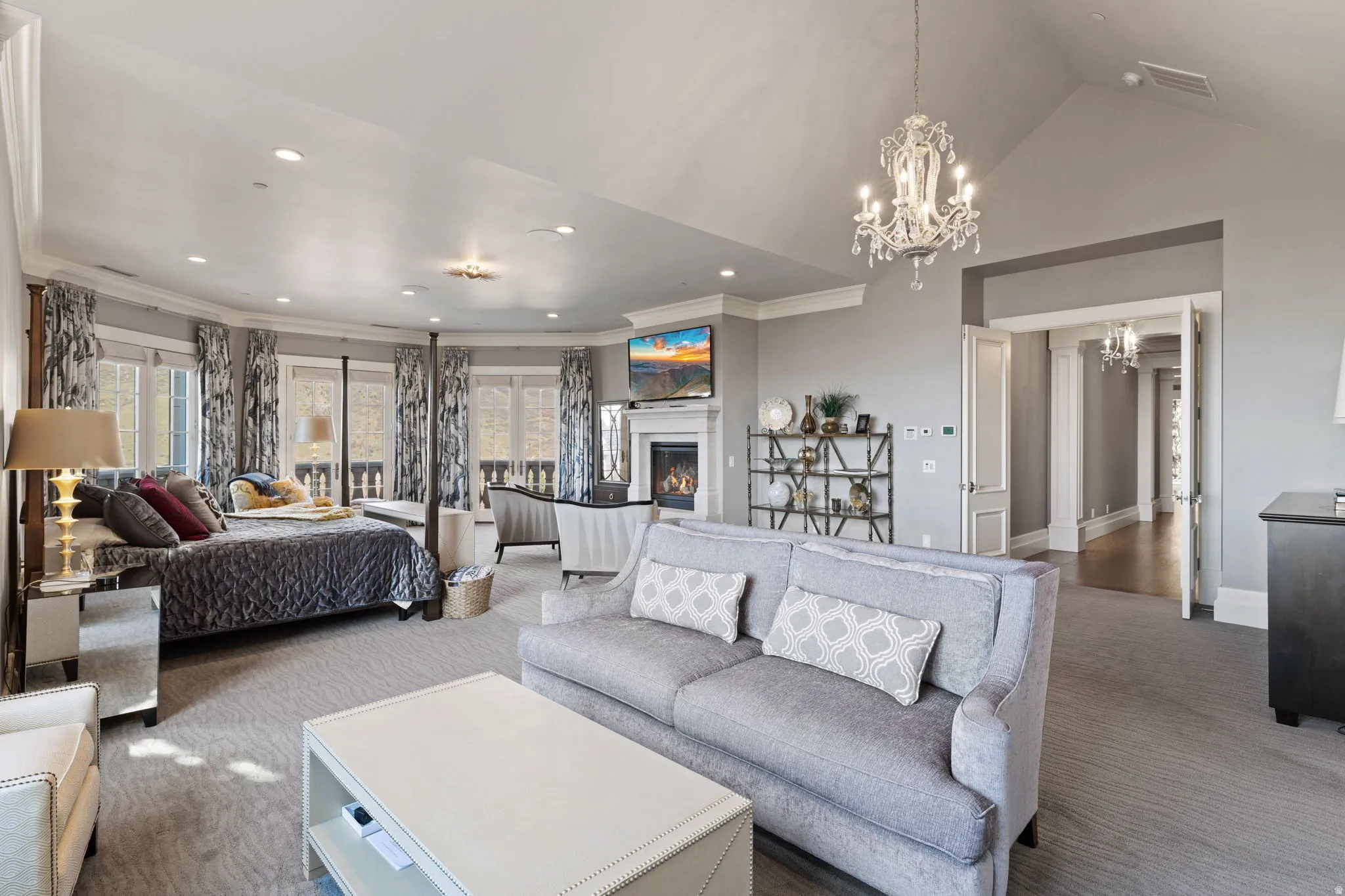 Bedroom featuring ornamental molding, a lit fireplace, carpet floors, suspended lighting, and access to exterior