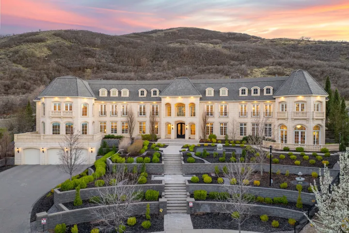 View of front of house with french doors, stone siding, a mountain view, and asphalt driveway