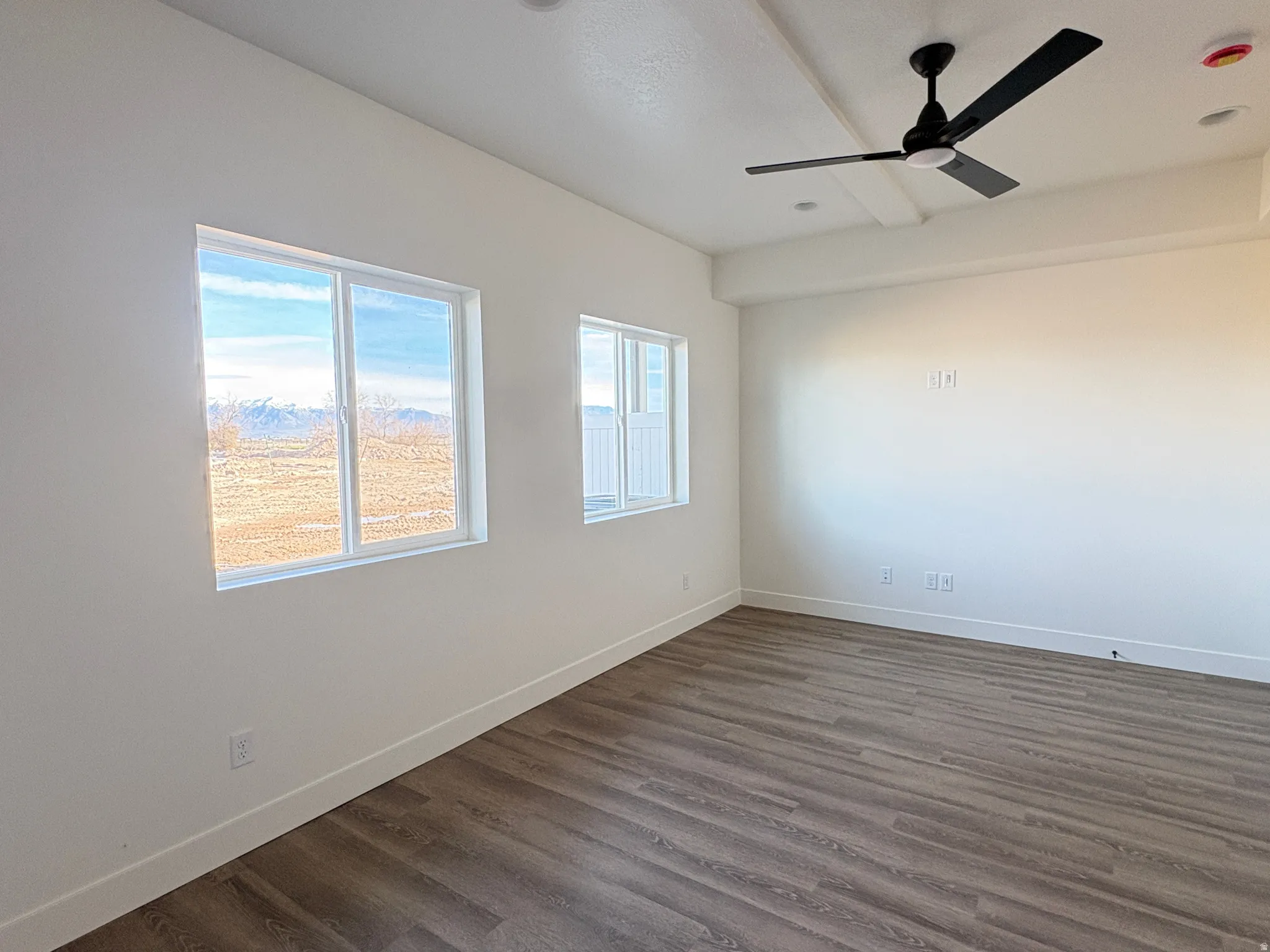 Unfurnished room with dark wood-style flooring and a ceiling fan