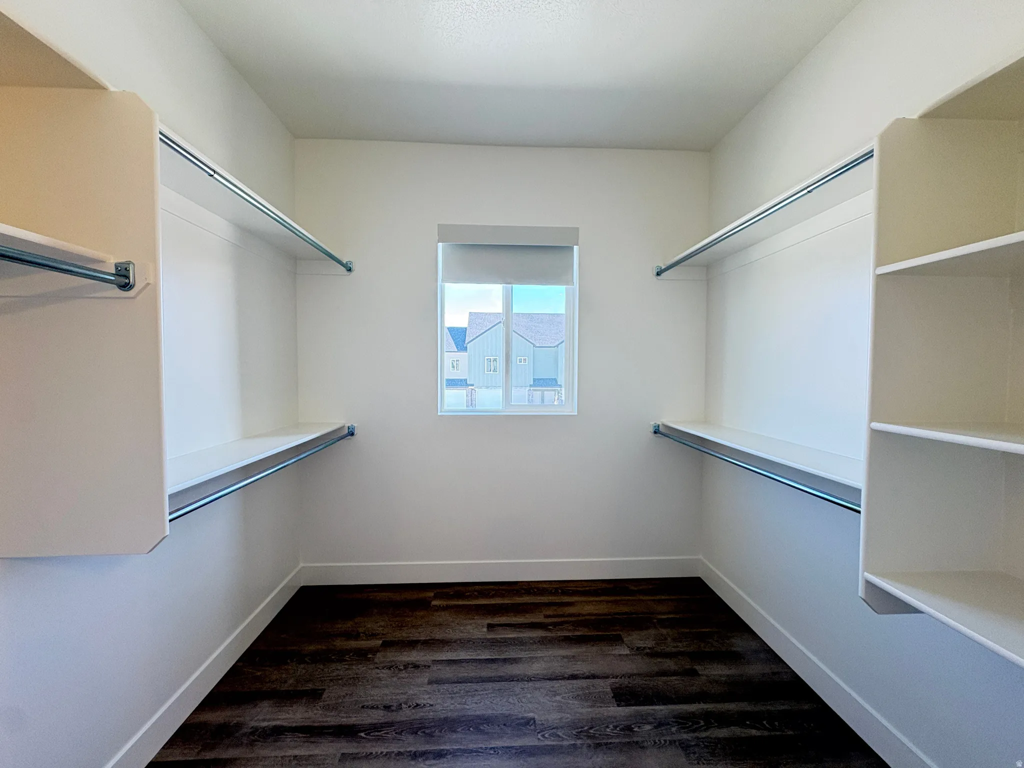 Walk in closet featuring dark wood-style flooring