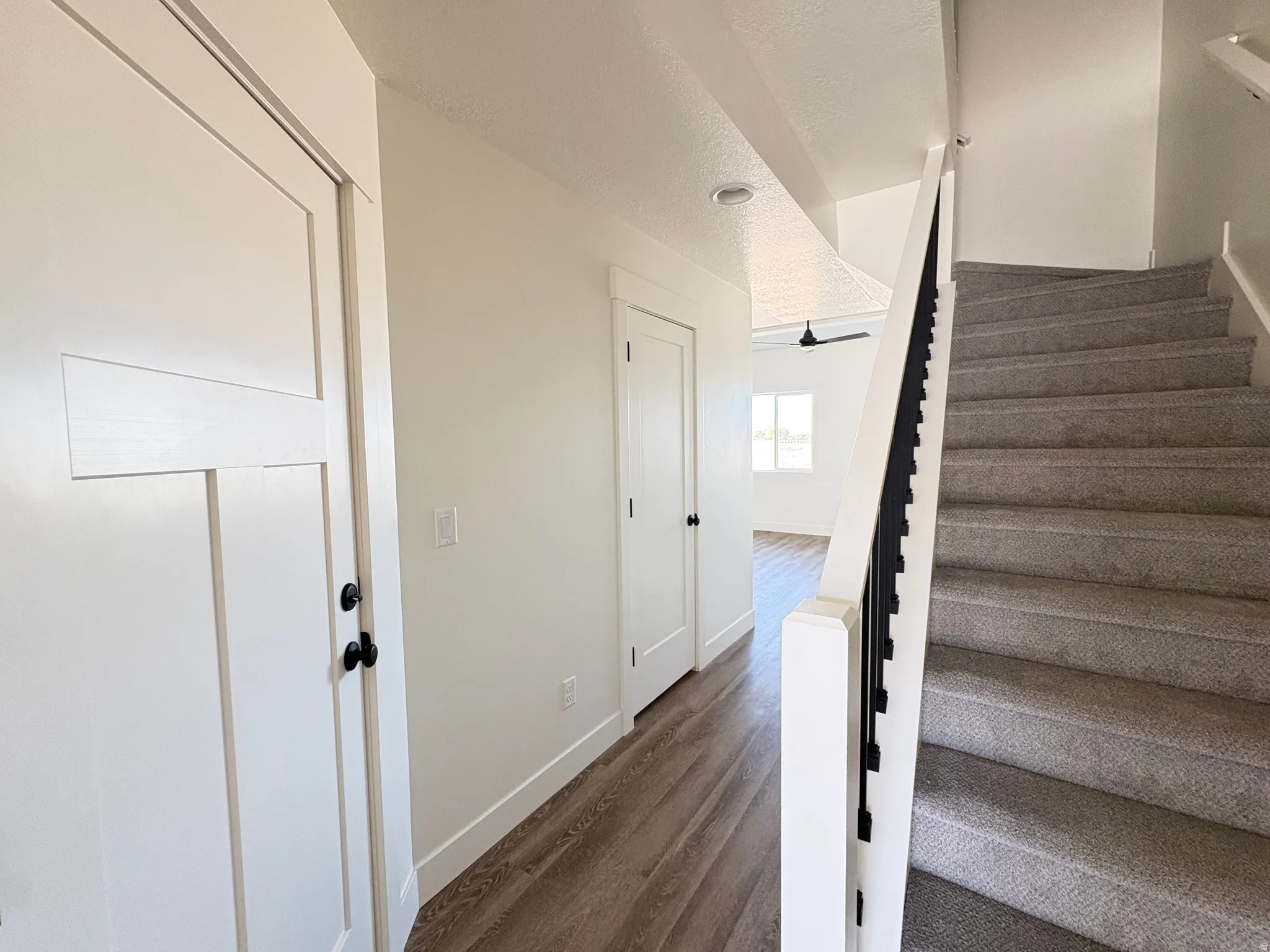 Staircase featuring wood finished floors and a textured ceiling