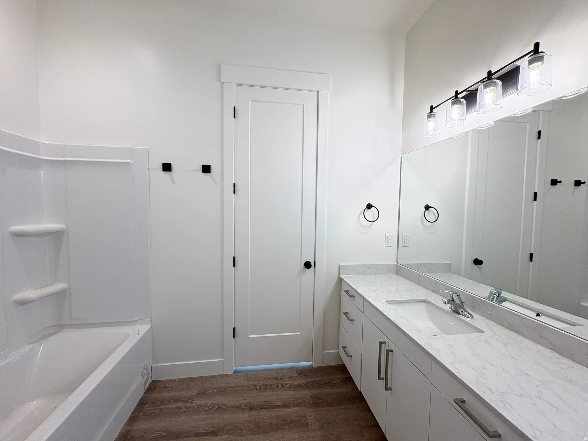 Bathroom with vanity, dark wood finished floors, and tub / shower combination