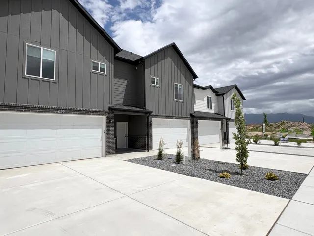 Modern townhome exterior featuring vertical siding and brick accents