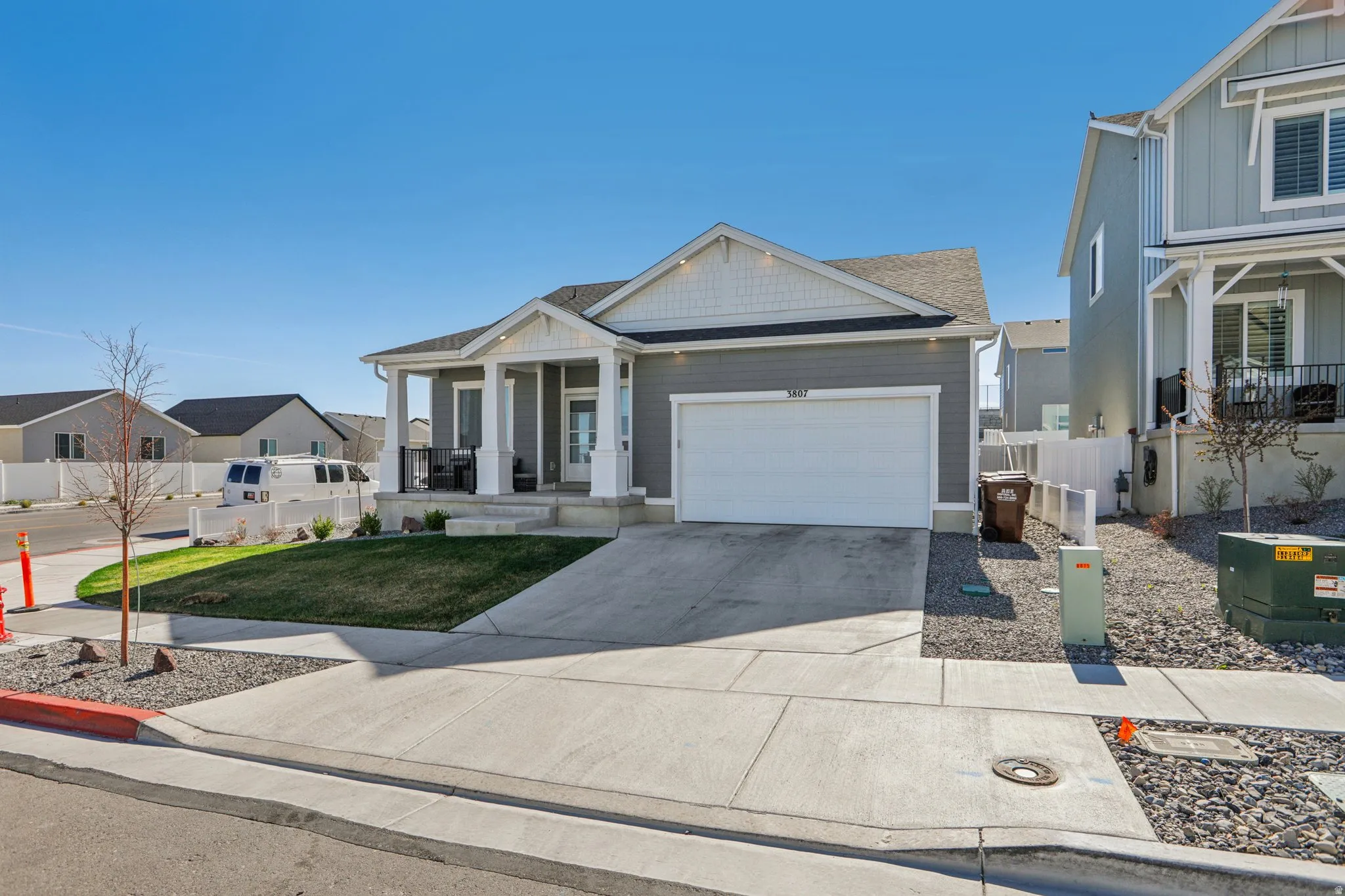 View of front of house with a porch, concrete driveway, a garage, a residential view, and board and batten siding