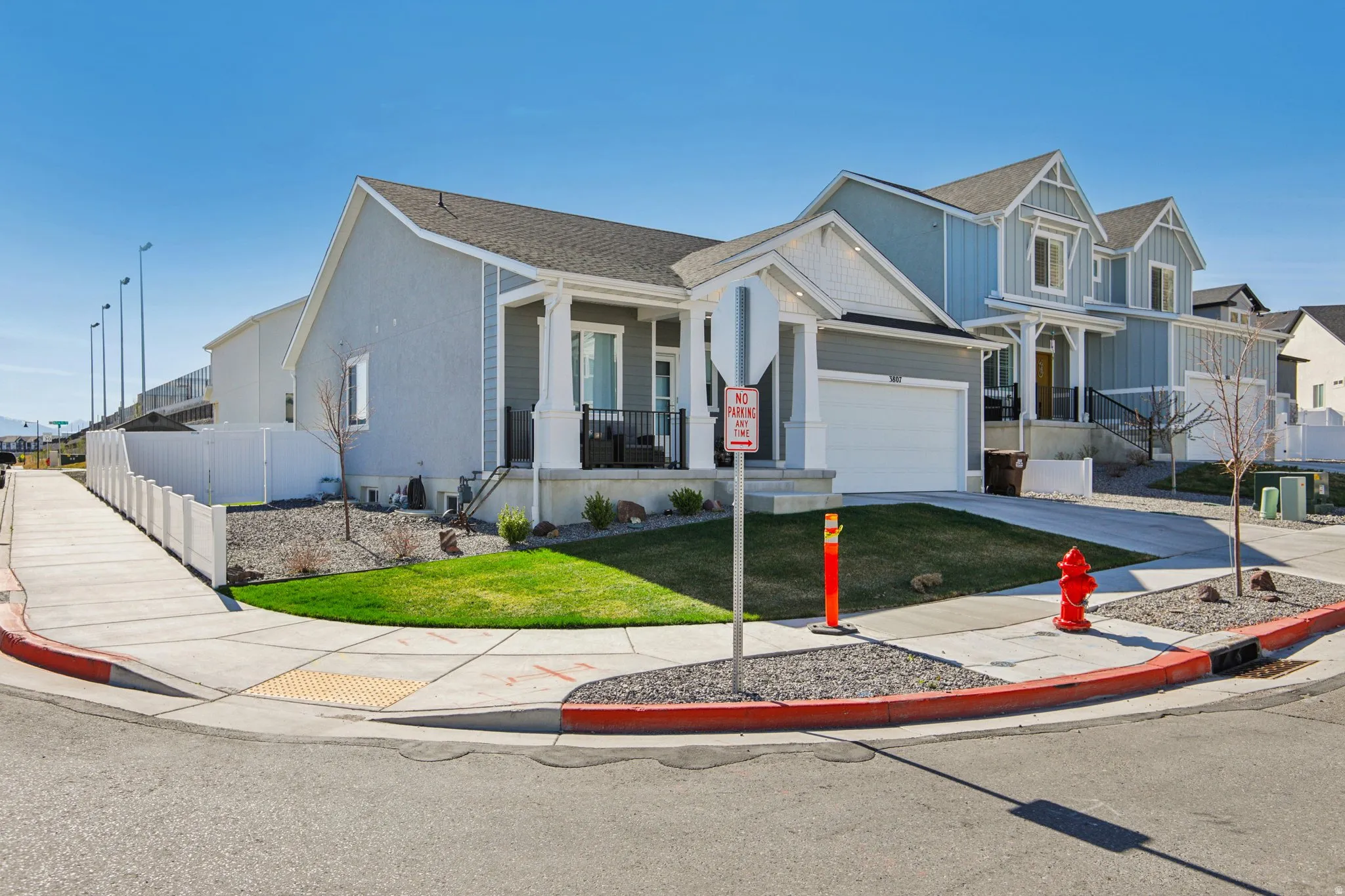 View of front of house with concrete driveway, covered porch, a shingled roof, and an attached garage