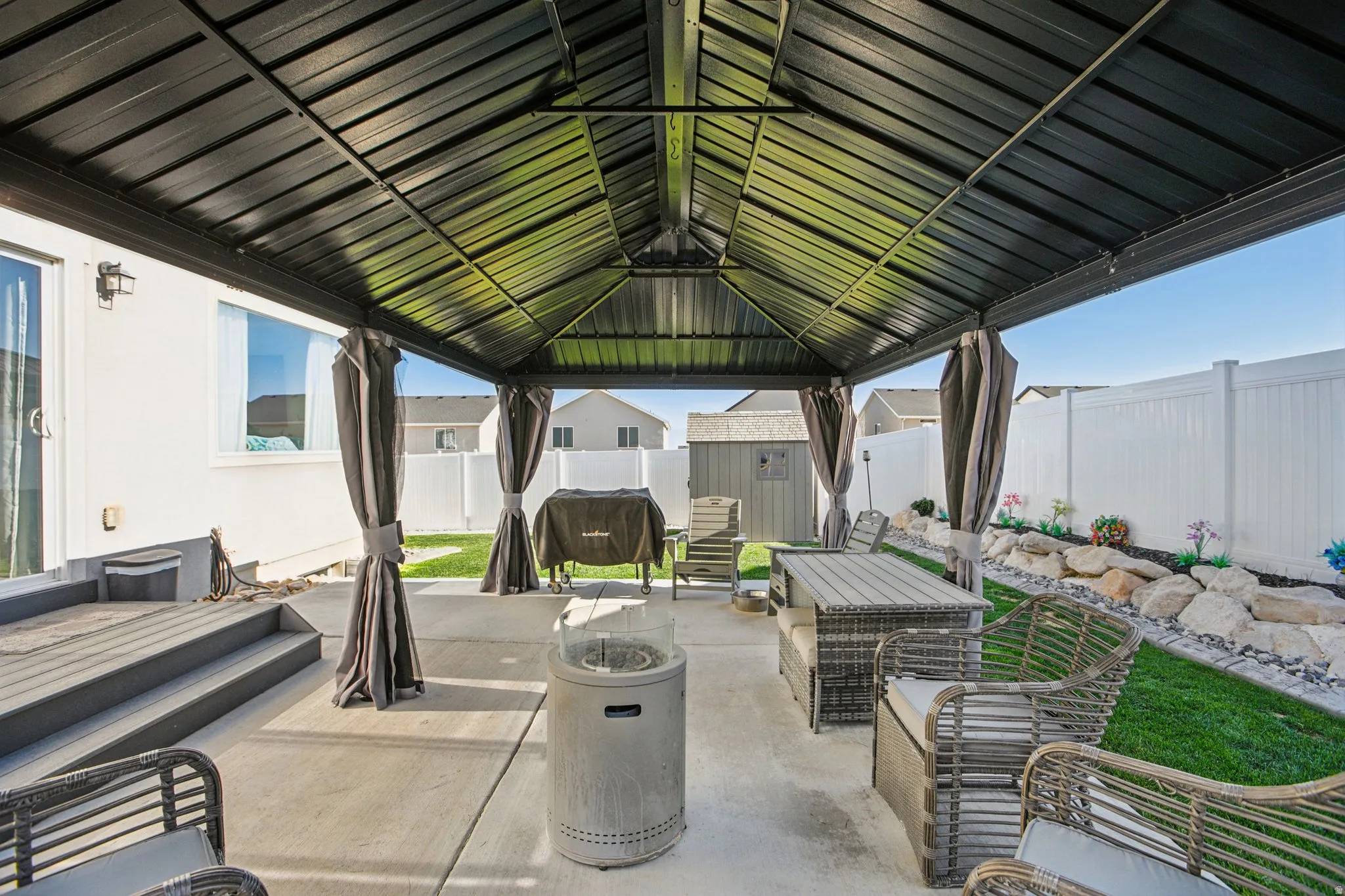 Fenced backyard with a storage unit, a patio, and outdoor dining space