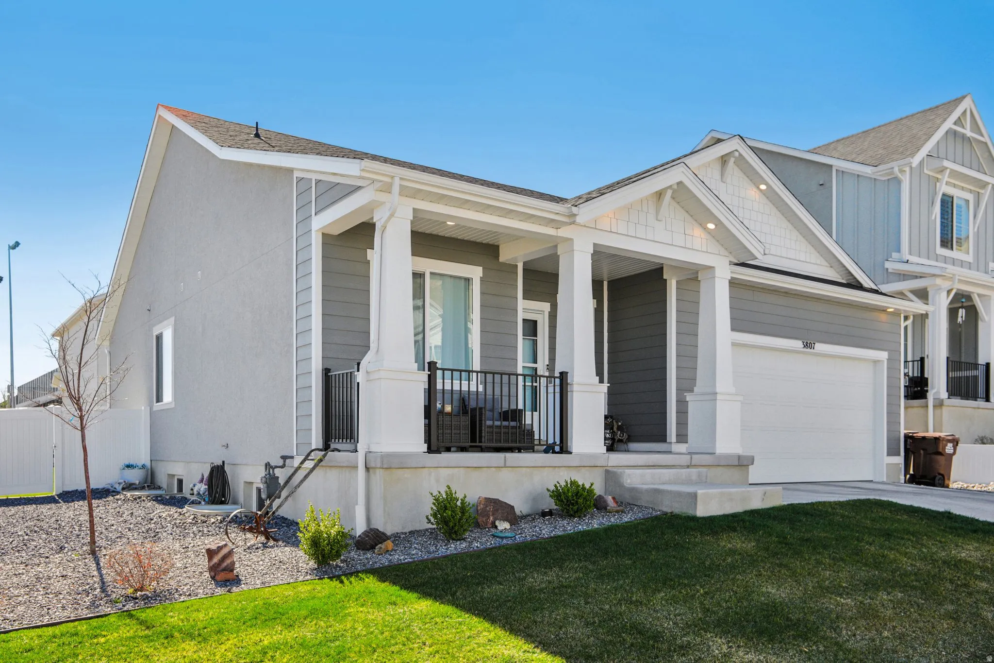 View of front facade featuring a porch, a front yard, concrete driveway, and an attached garage