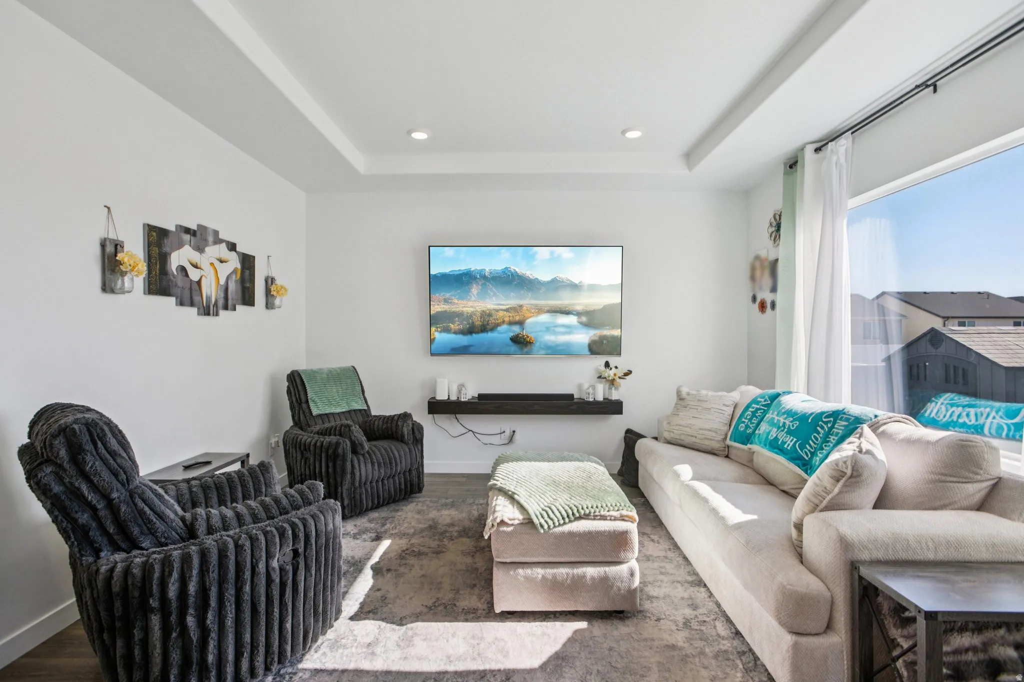 Living room with wood finished floors, a tray ceiling, and recessed lighting