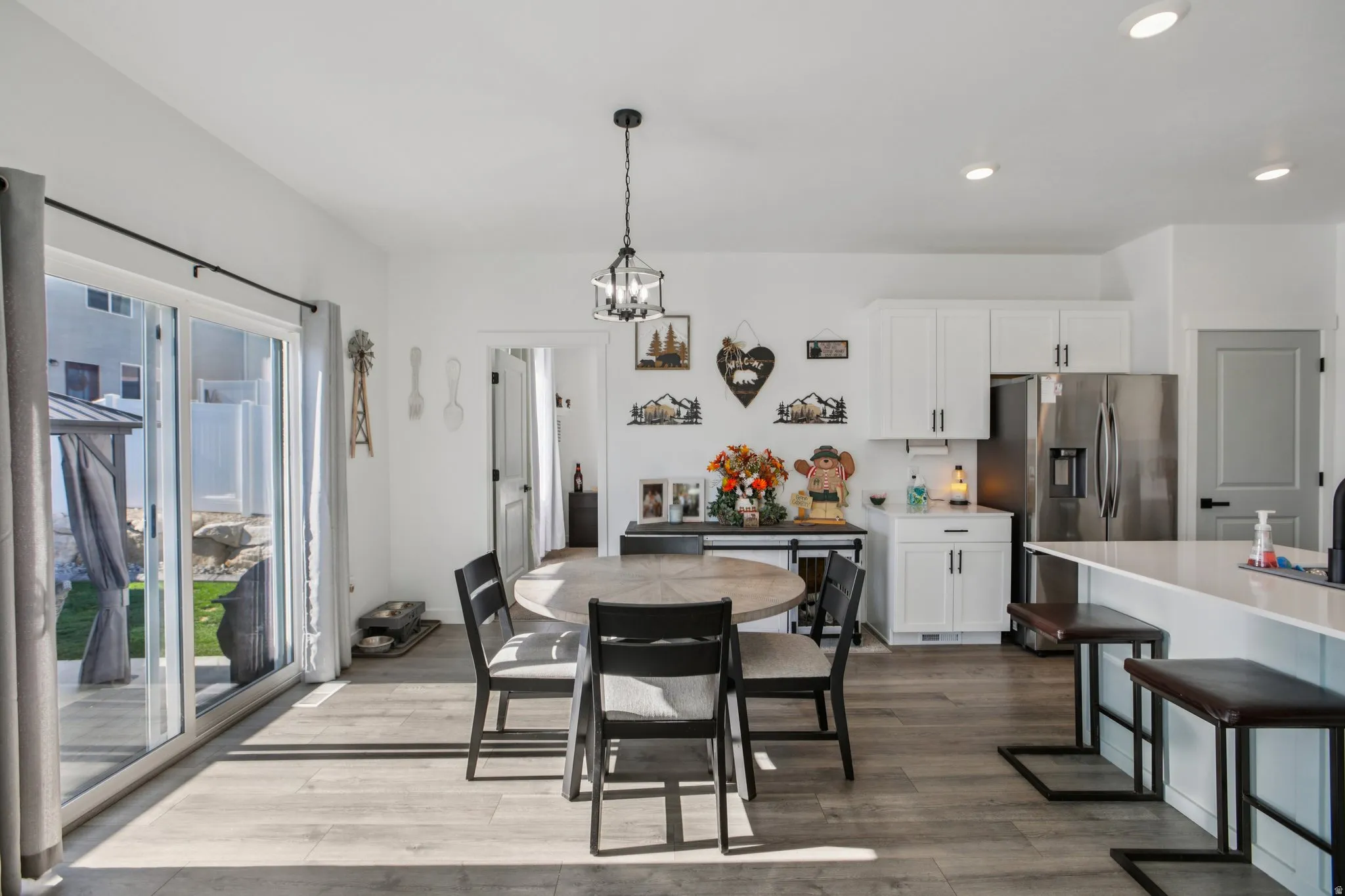 Dining area with dark wood-style floors and suspended lighting