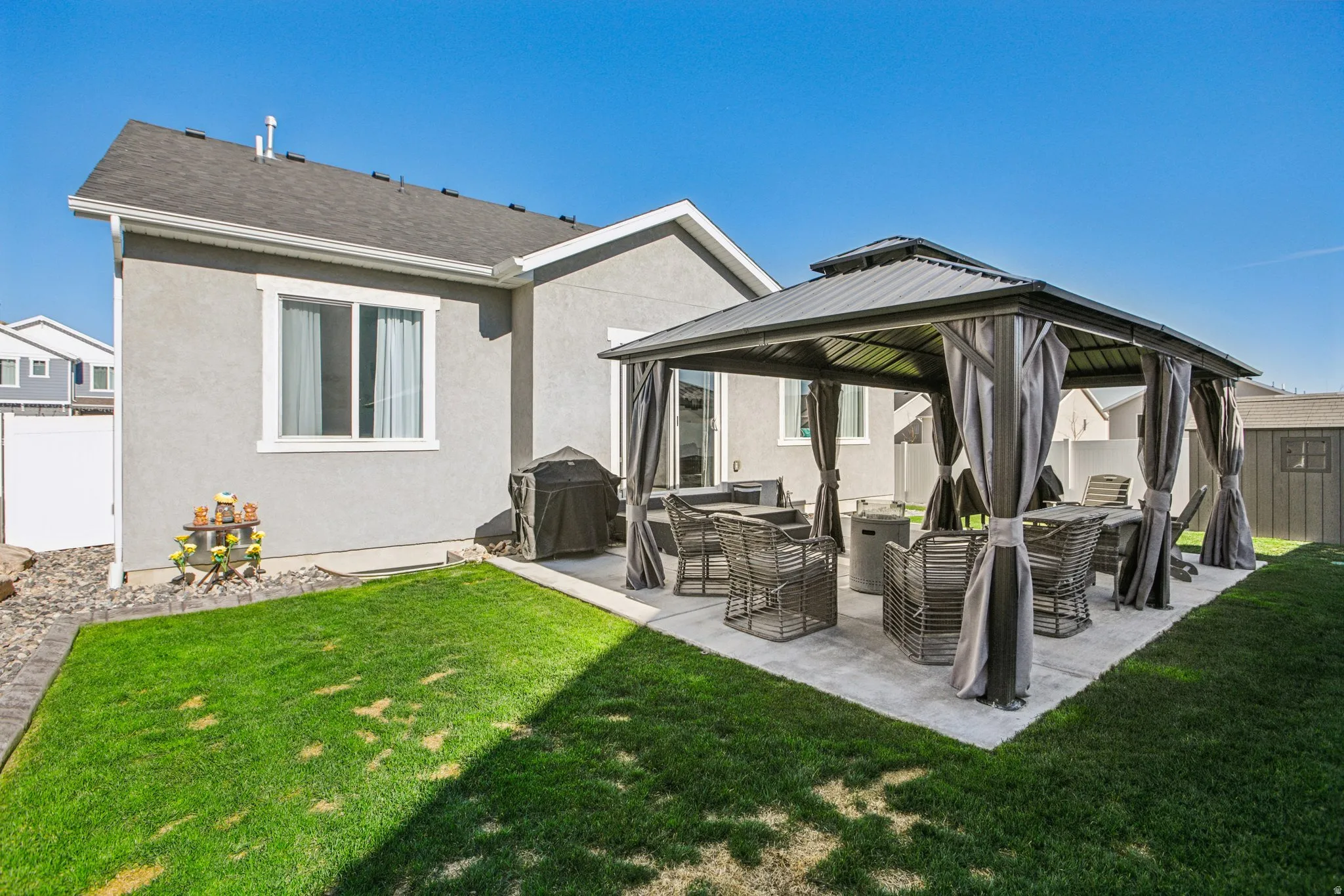 Rear view of house featuring a gazebo, a patio area, a fenced backyard, stucco siding, and outdoor lounge area