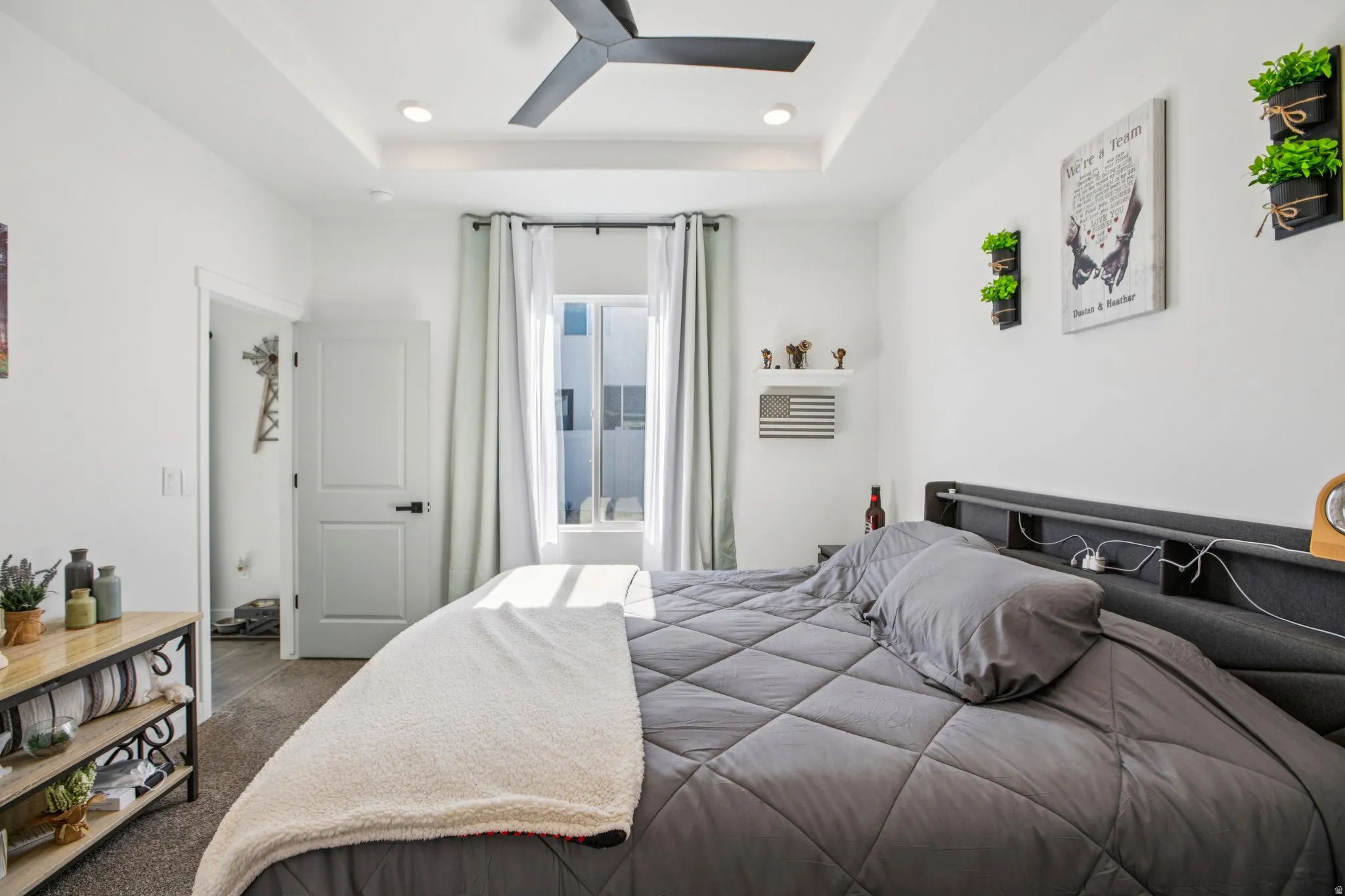 Carpeted bedroom with a raised ceiling, a ceiling fan, and recessed lighting