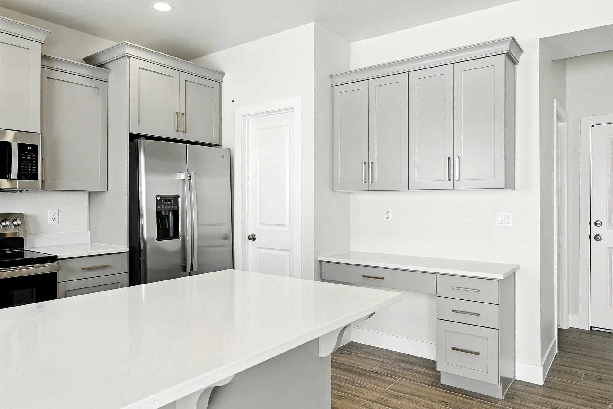 Kitchen featuring stainless steel appliances, gray cabinets, wood tiled floors, recessed lighting, and light stone counters