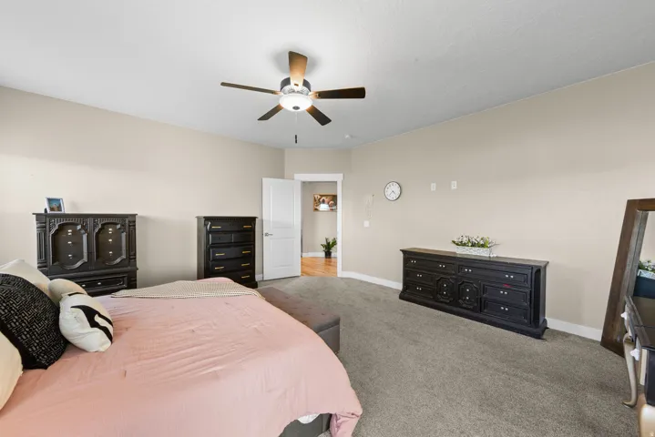 Carpeted bedroom featuring baseboards and ceiling fan