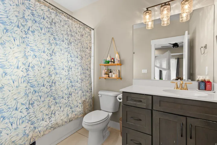 Full bath featuring vanity, shower / tub combo, and light tile patterned floors