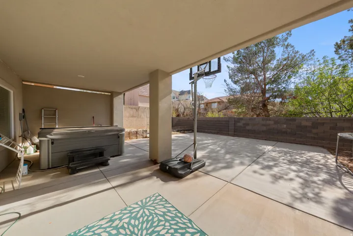 Fenced backyard featuring a patio area and a hot tub