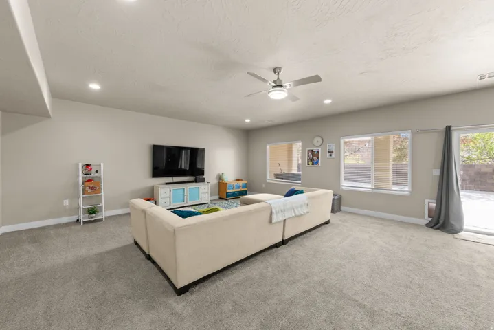 Living area featuring a ceiling fan, light carpet, recessed lighting, and a textured ceiling