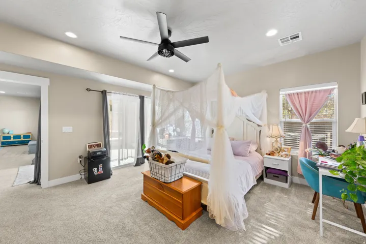 Bedroom with access to exterior, light carpet, ceiling fan, and recessed lighting
