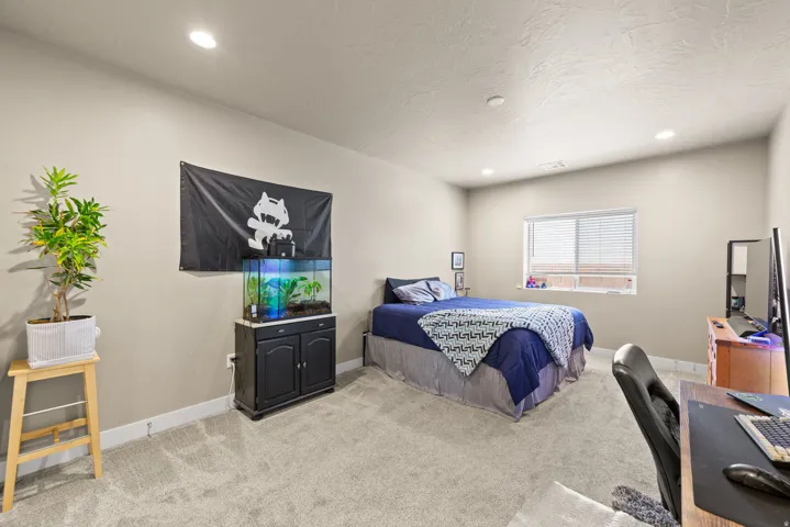 Bedroom featuring an office area, light colored carpet, and recessed lighting