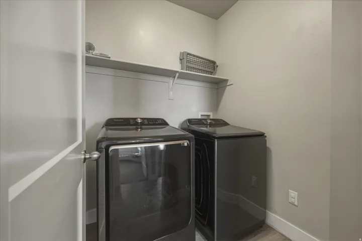Laundry room with washer and dryer, and wood floors