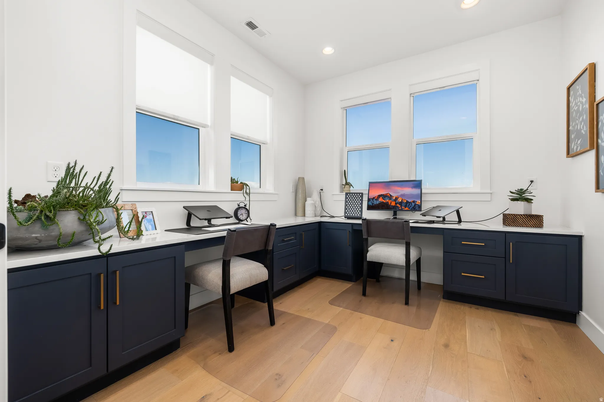 Home office with built in desk, light wood-style flooring, recessed lighting, and plenty of natural light