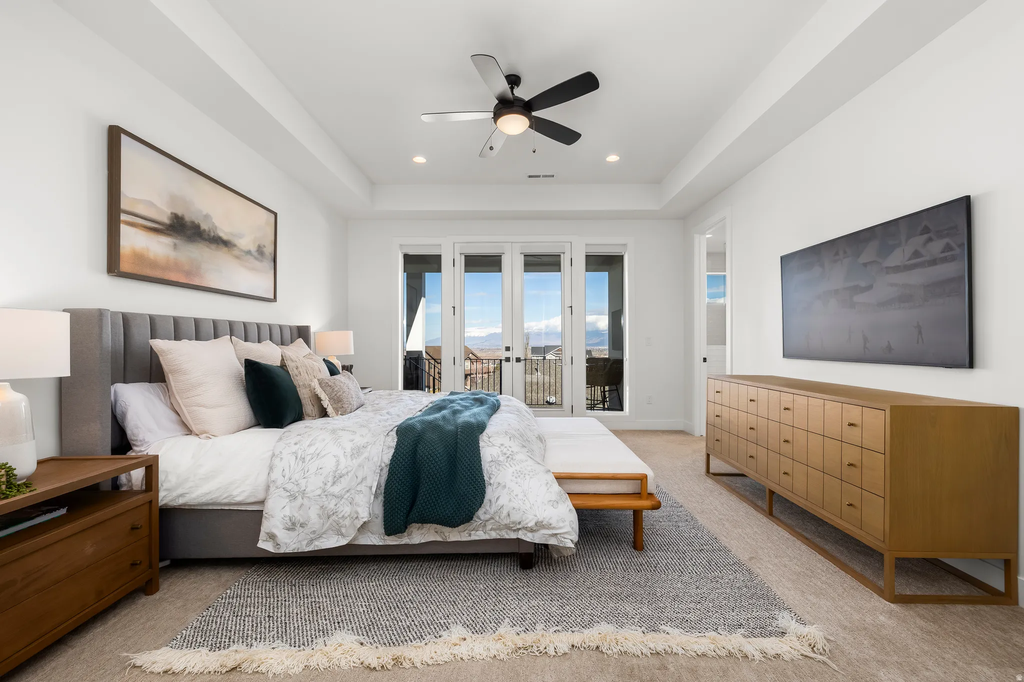 Bedroom with light carpet, a tray ceiling, french doors, ceiling fan, and access to exterior
