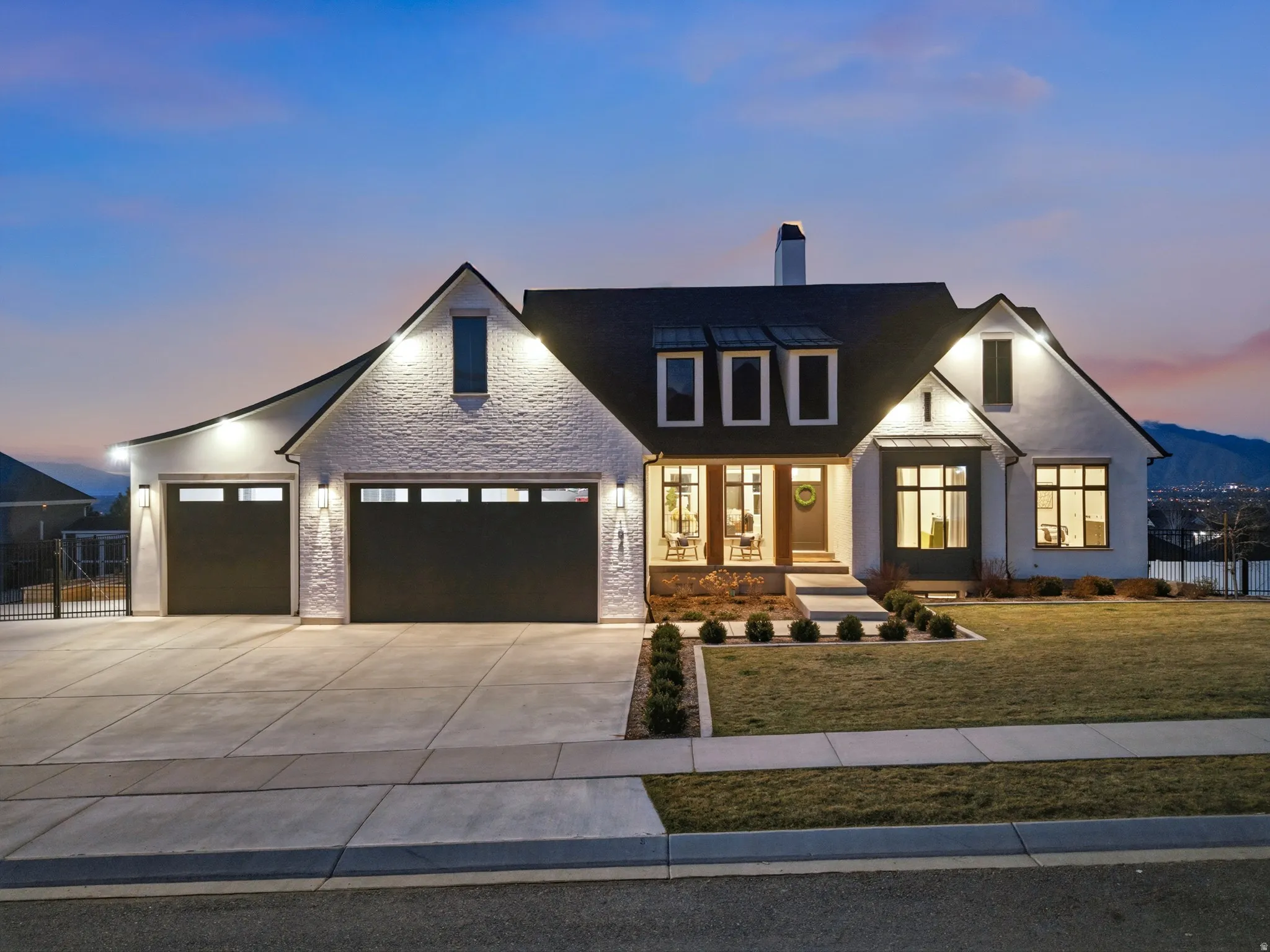 View of front of home featuring an attached garage, driveway, a chimney, and stone siding