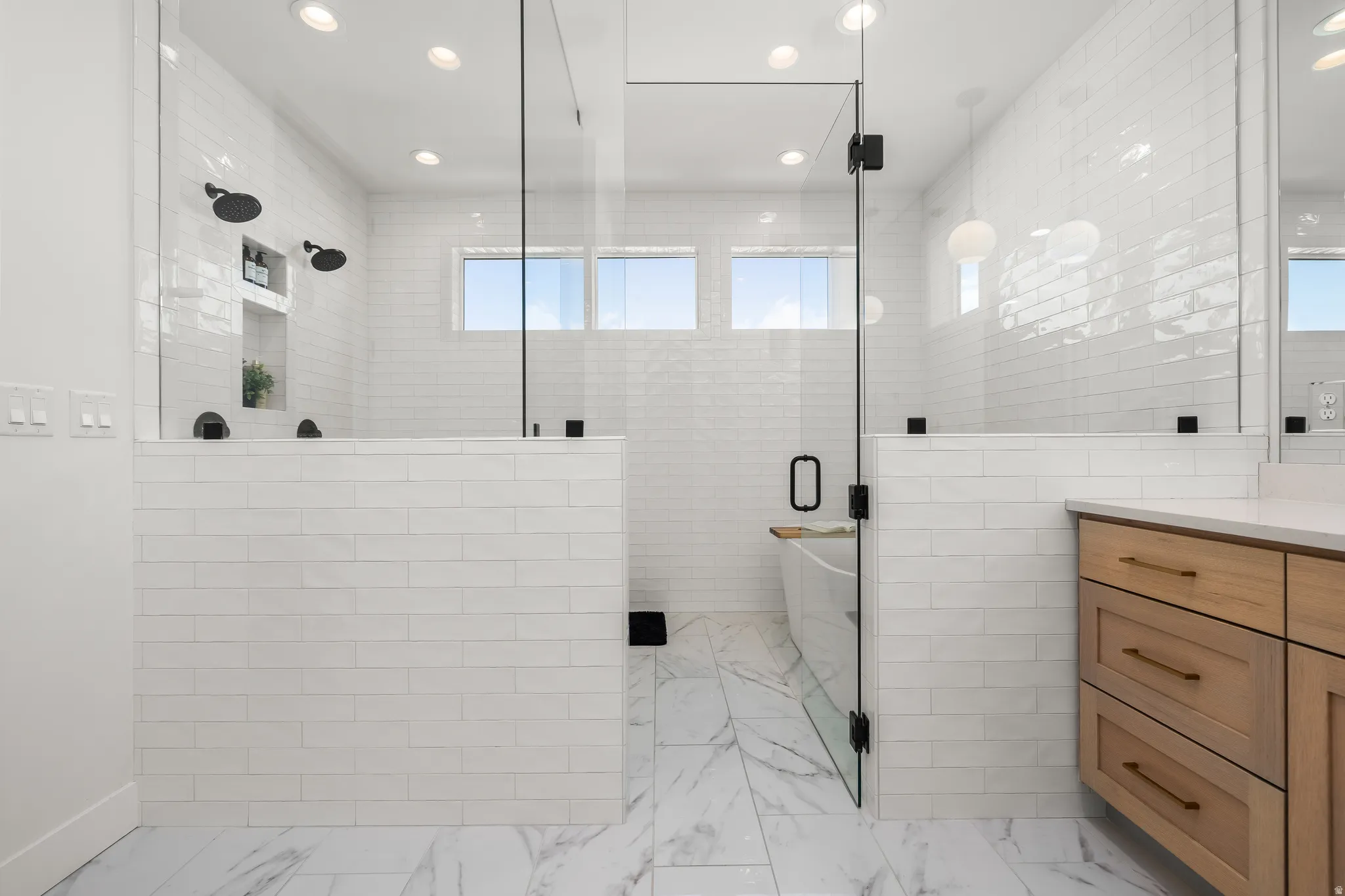 Bathroom featuring tile walls, vanity, a stall shower, and recessed lighting
