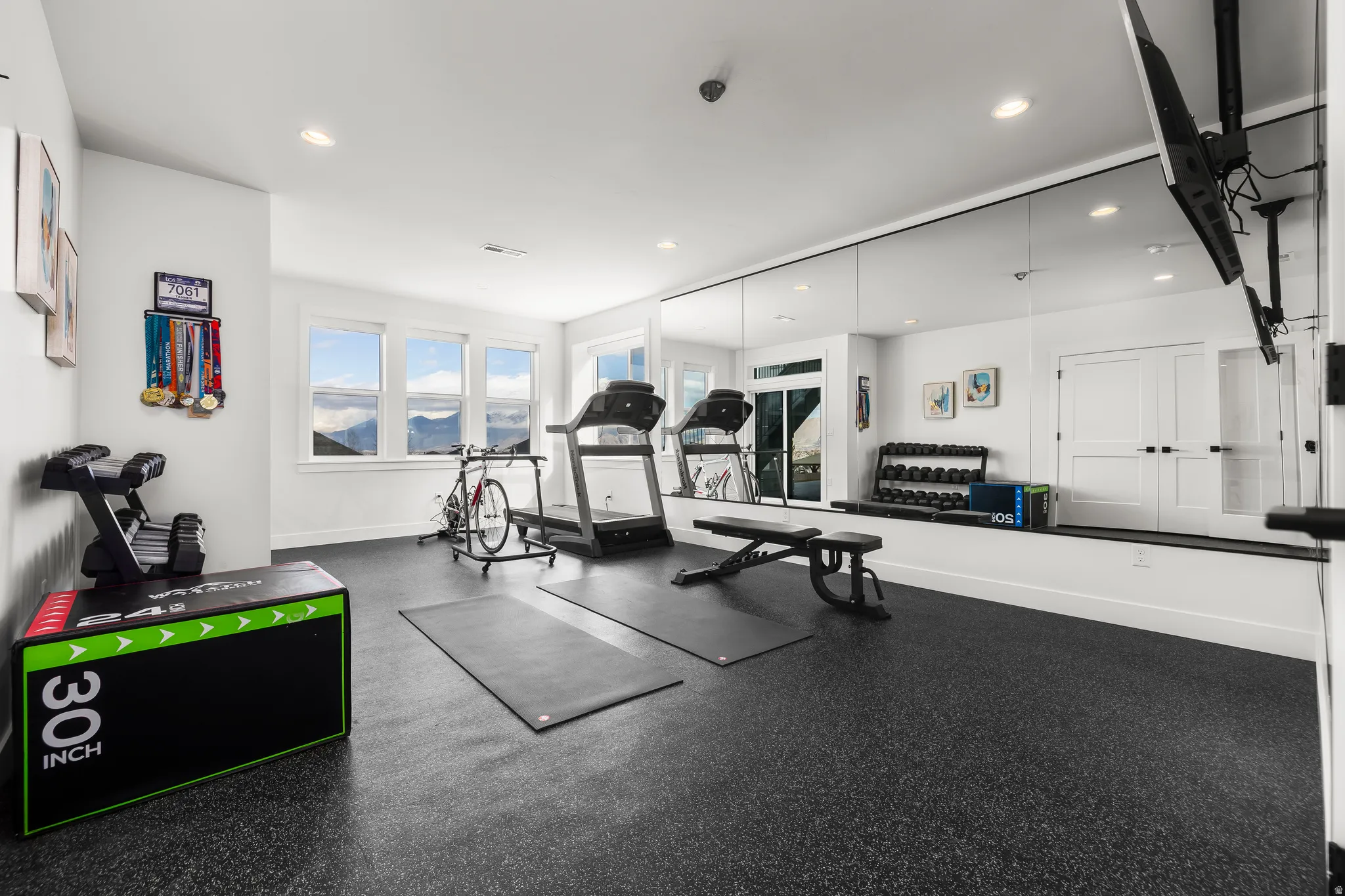 Exercise area featuring dark rubber floors and recessed lighting