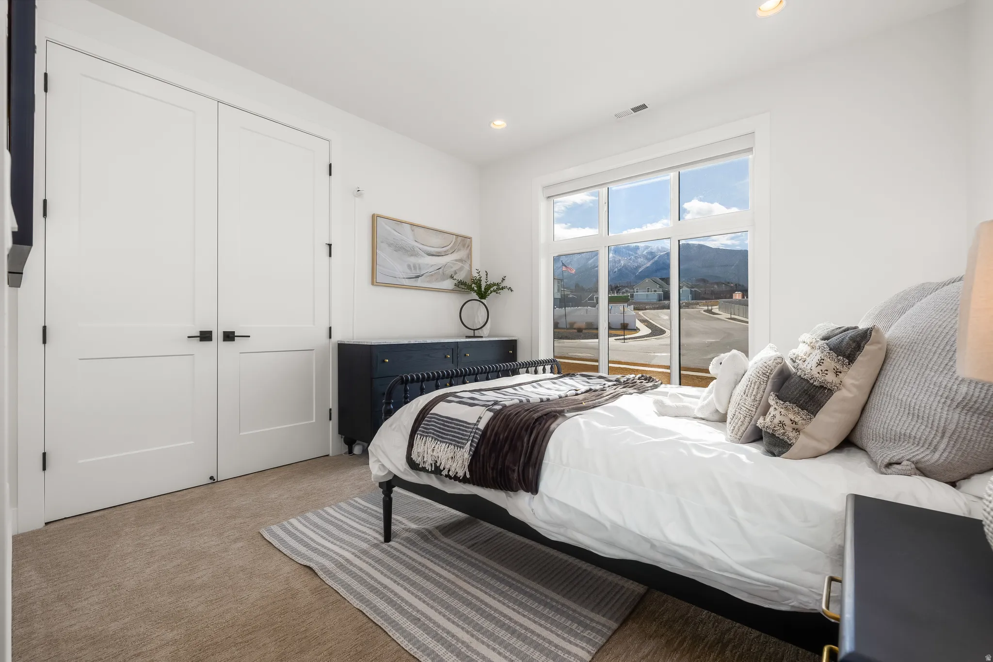 Bedroom featuring light carpet, recessed lighting, a mountain view, and a closet