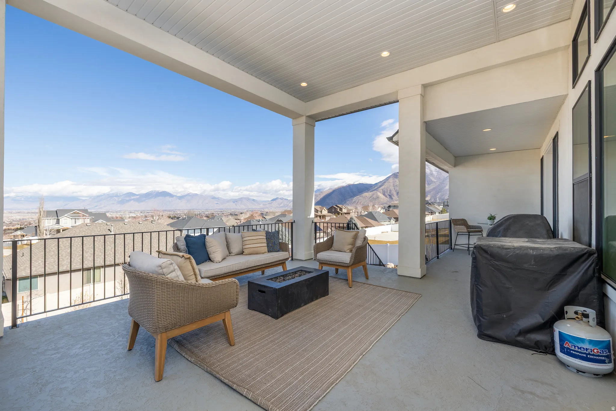 View of patio featuring a mountain view, an outdoor living space with a fire pit, and a residential view