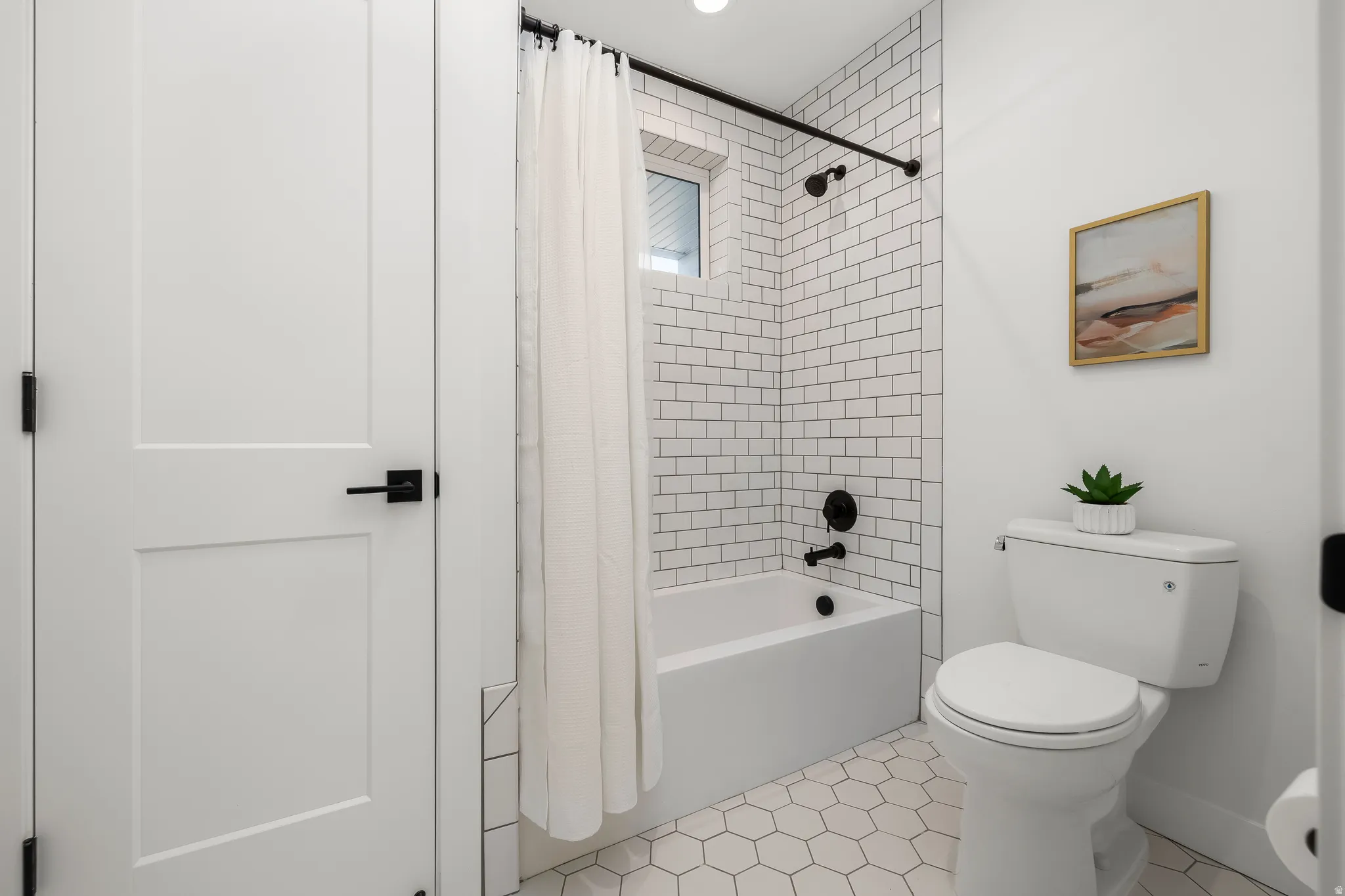 Full bathroom with shower / bath combo with shower curtain and light tile patterned flooring