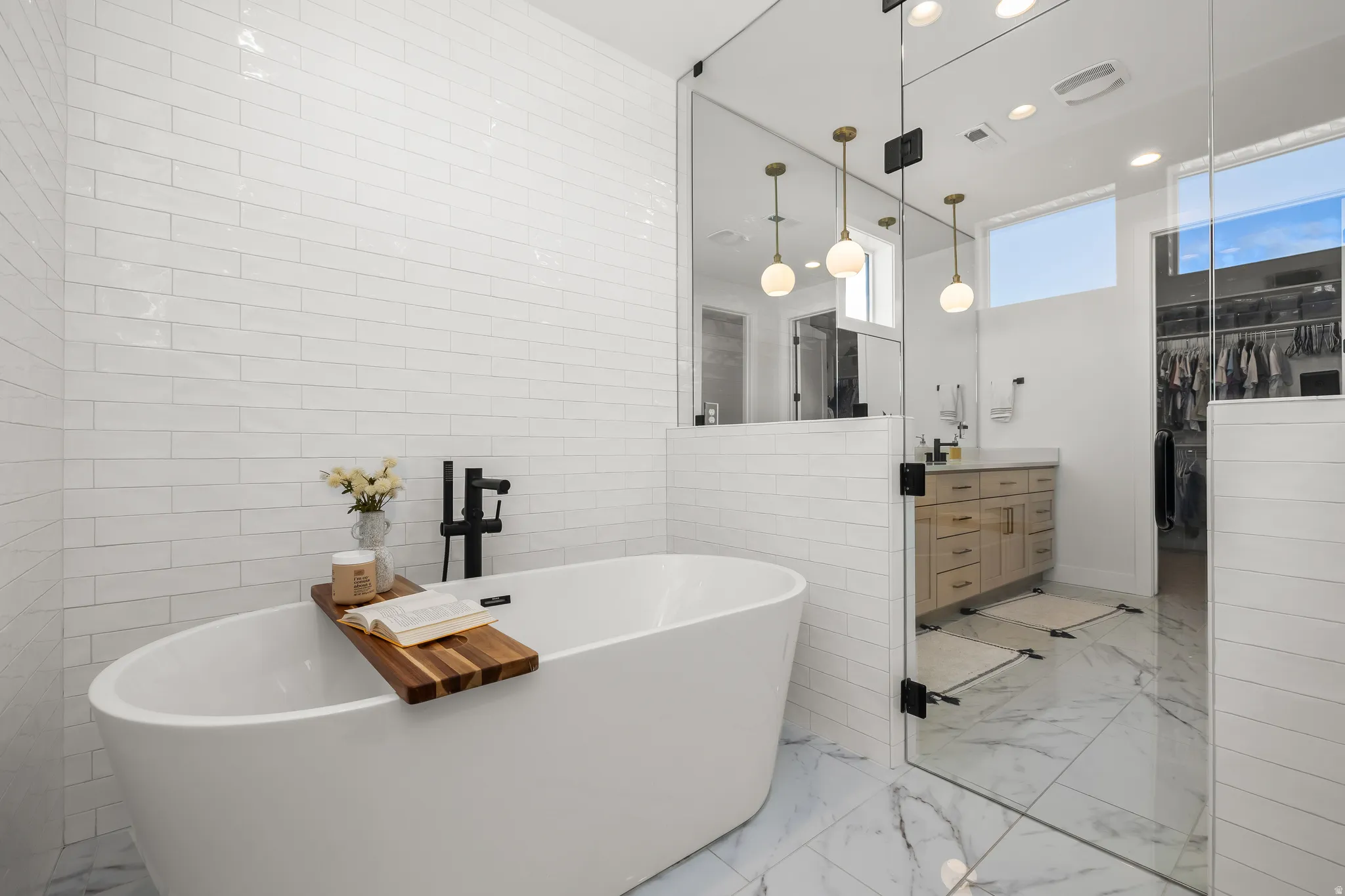 Full bathroom with vanity, a spacious closet, a freestanding bath, and recessed lighting