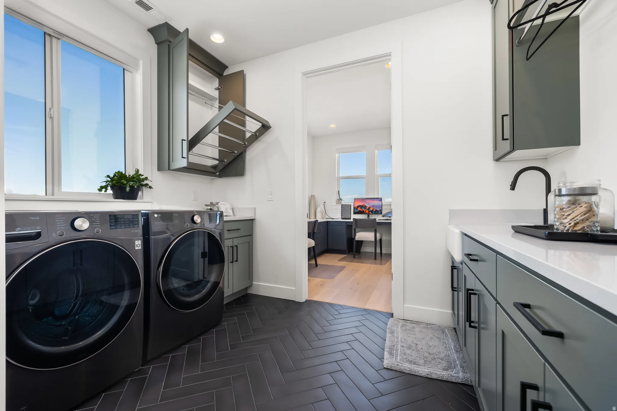 Laundry room featuring parquet flooring, cabinet space, washing machine and dryer, and recessed lighting