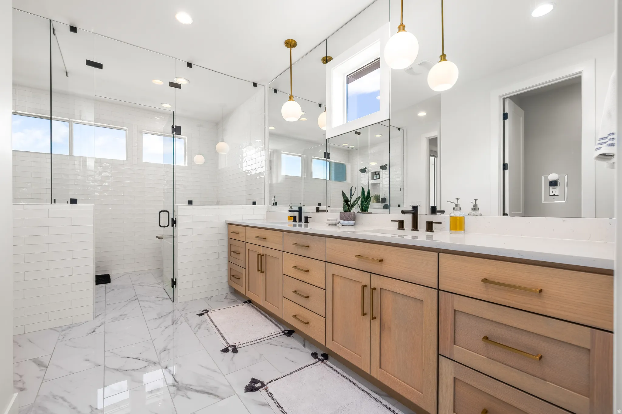 Full bath with a stall shower, double vanity, and recessed lighting