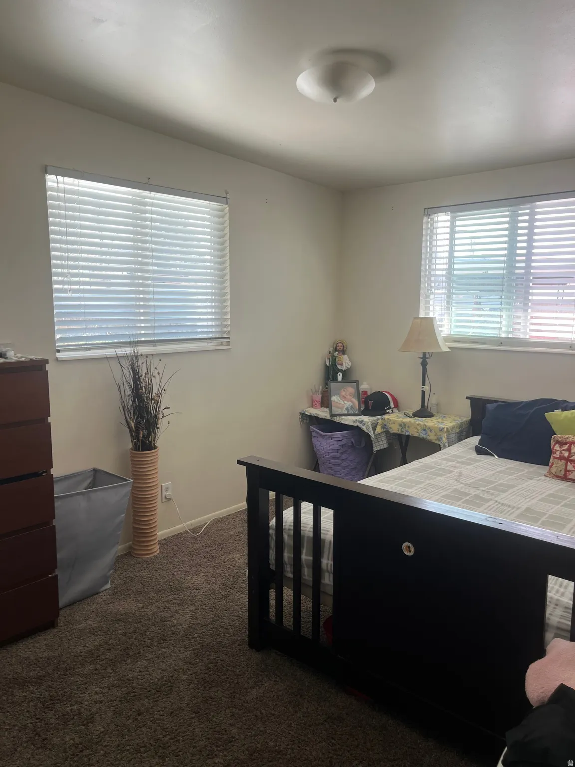Bedroom featuring dark colored carpet and baseboards