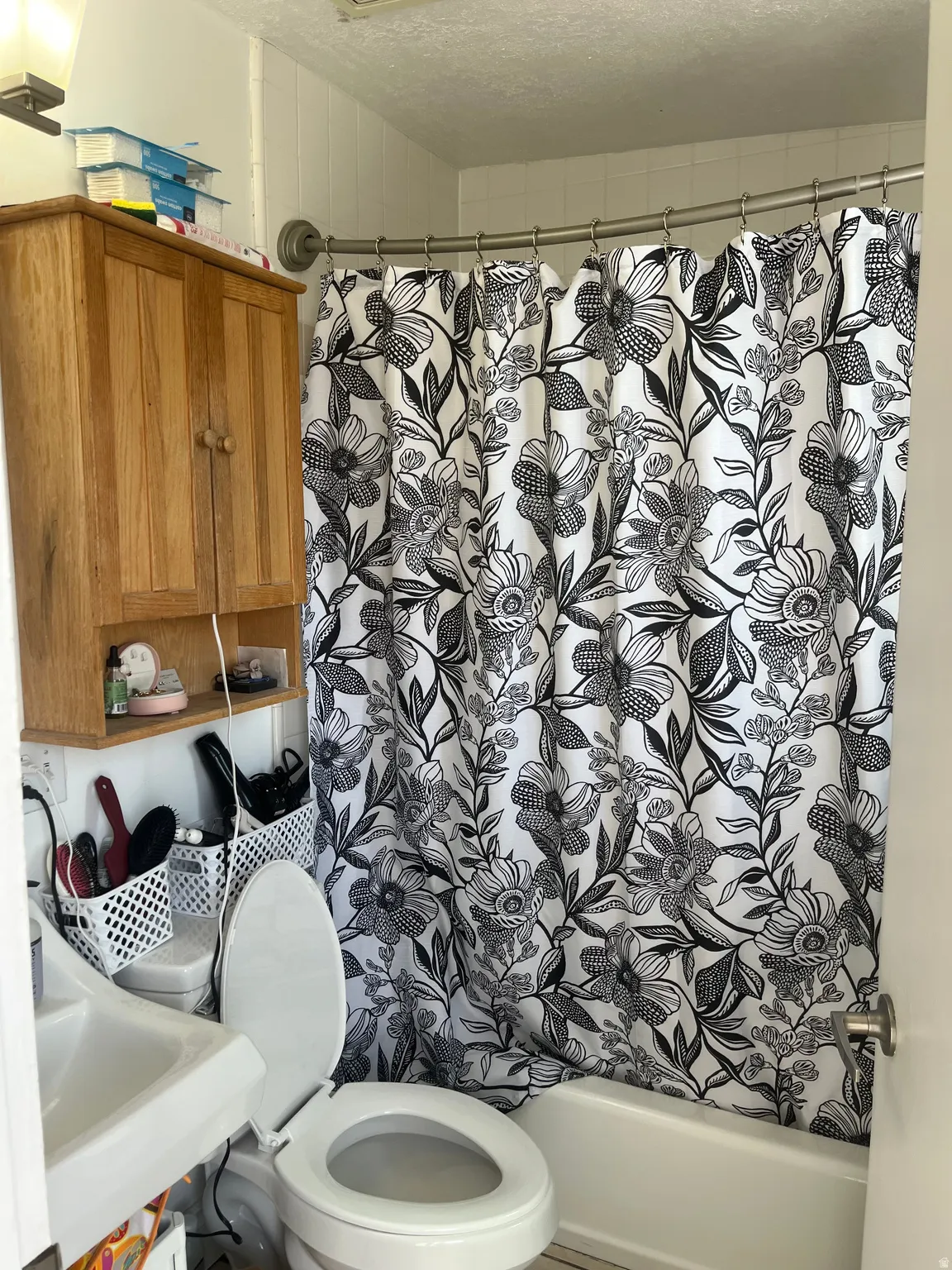 Bathroom with shower / bath combo with shower curtain and a textured ceiling