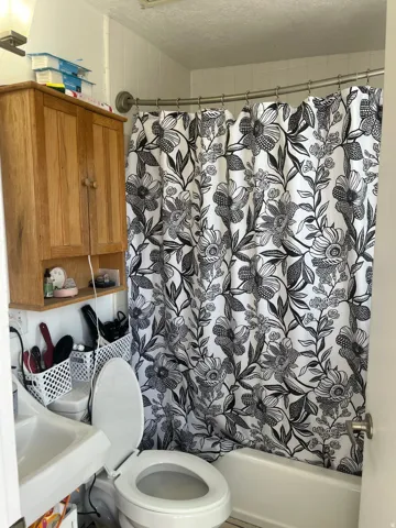 Bathroom with shower / bath combo with shower curtain and a textured ceiling