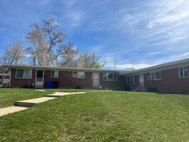 Ranch-style house featuring brick siding and a front lawn