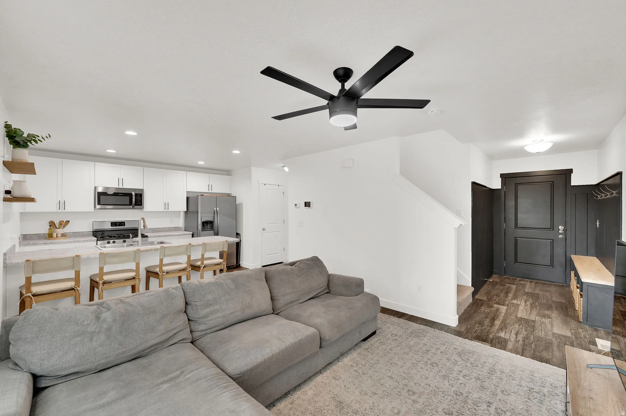 Living area featuring dark wood-style floors, recessed lighting, and a ceiling fan