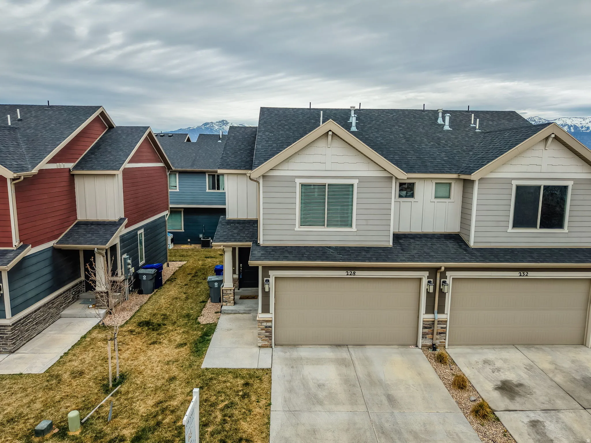 Craftsman inspired home featuring roof with shingles, board and batten siding, stone siding, a garage, and concrete driveway