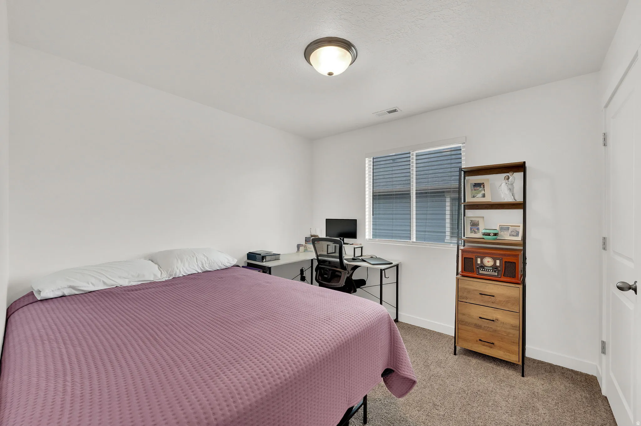 Bedroom featuring light carpet and baseboards
