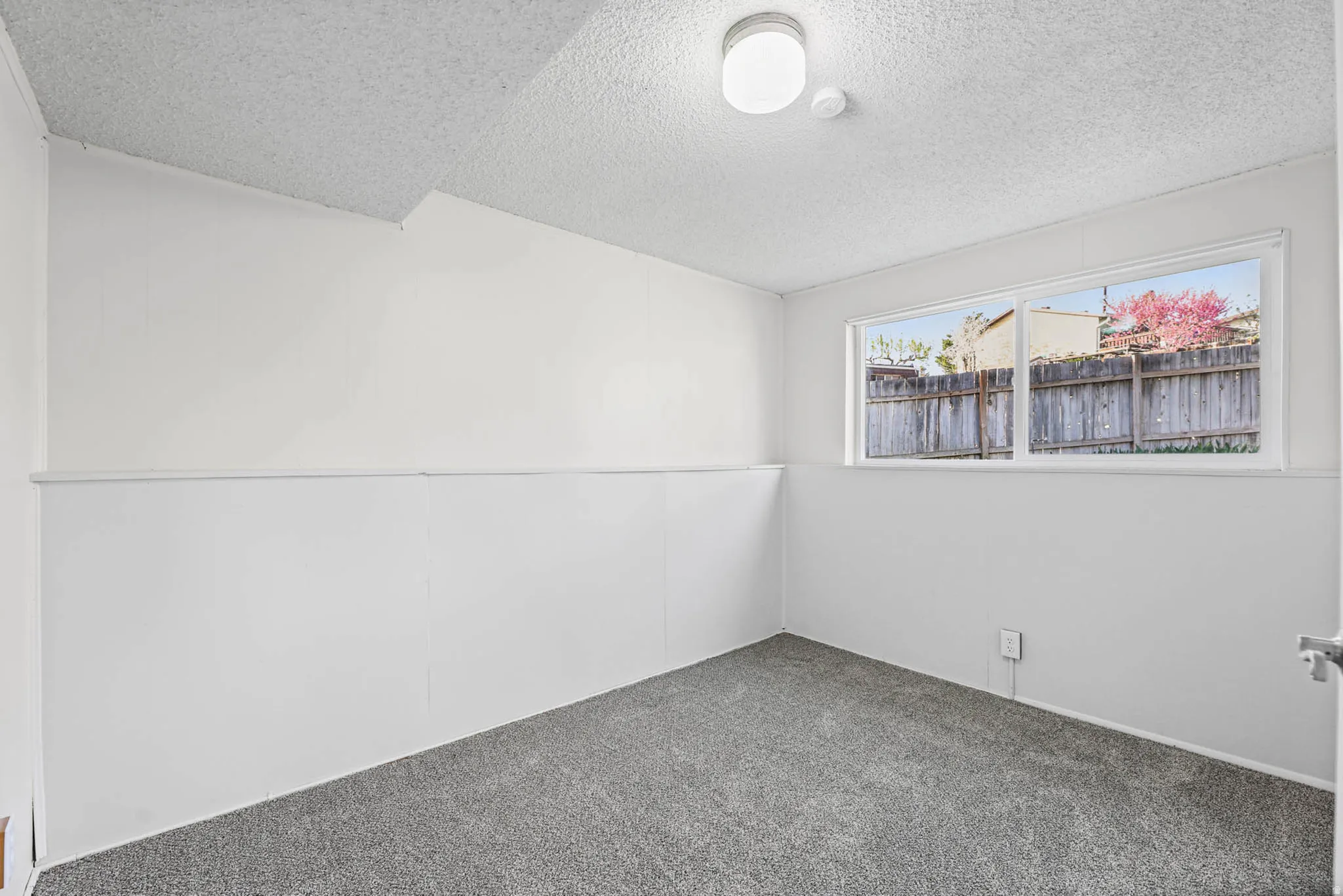 Carpeted empty room with a textured ceiling