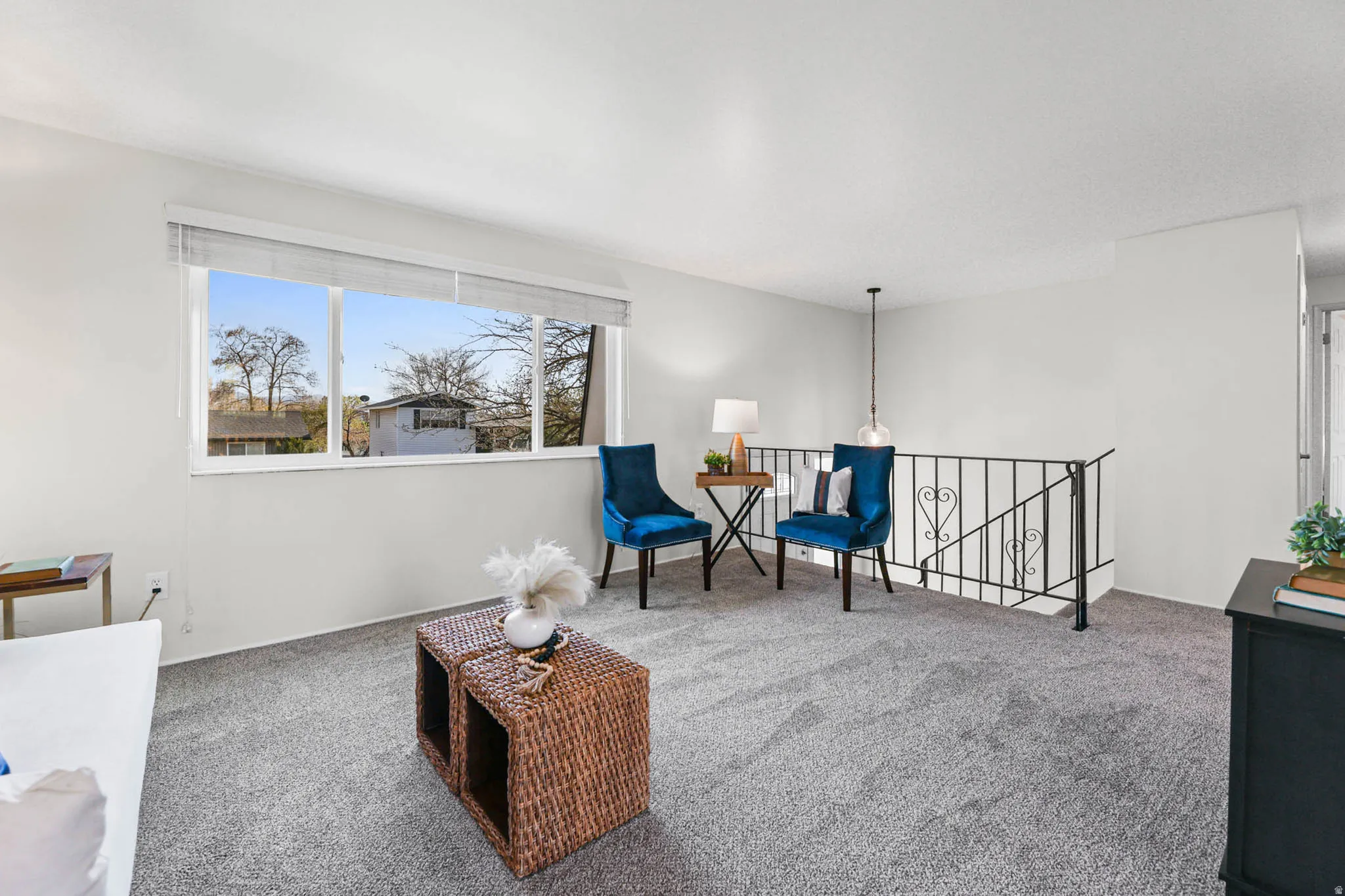 Living area with an upstairs landing and carpet floors, spacious feel