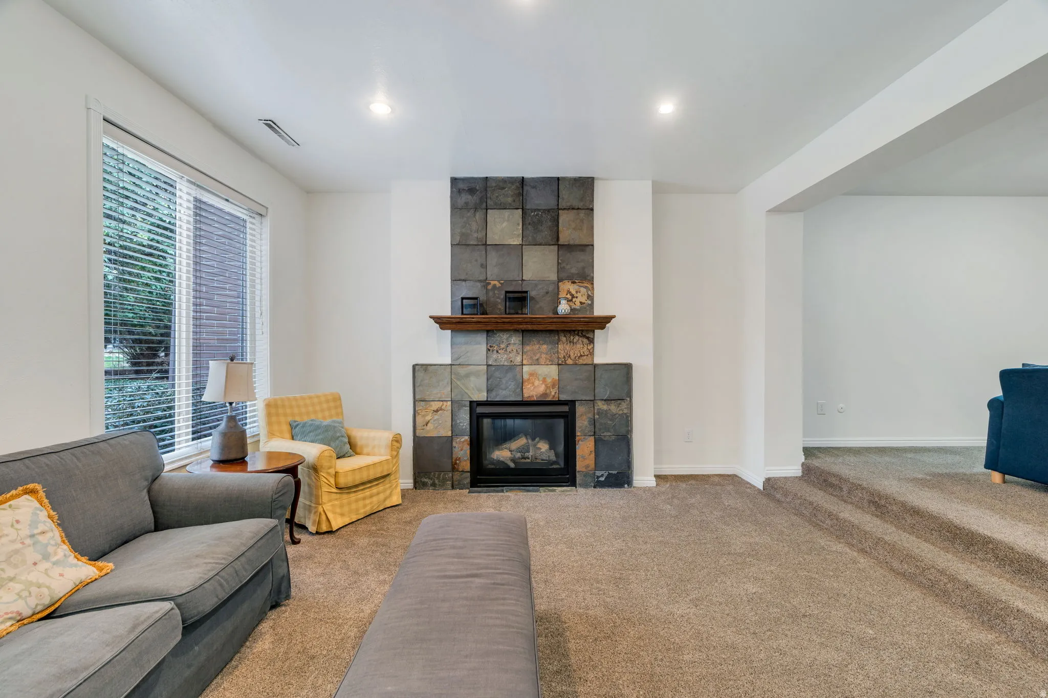 Carpeted living room with a fireplace and baseboards