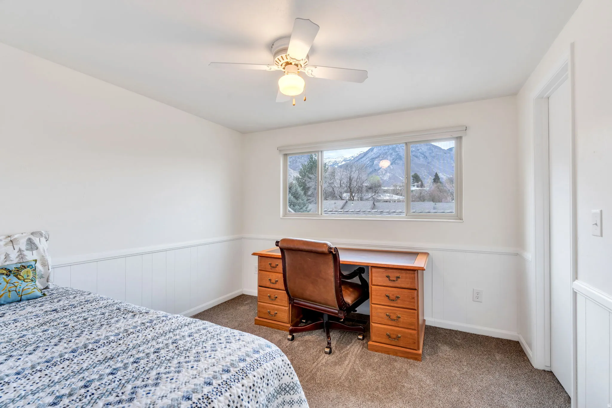 Bedroom featuring wainscoting, dark carpet, and ceiling fan