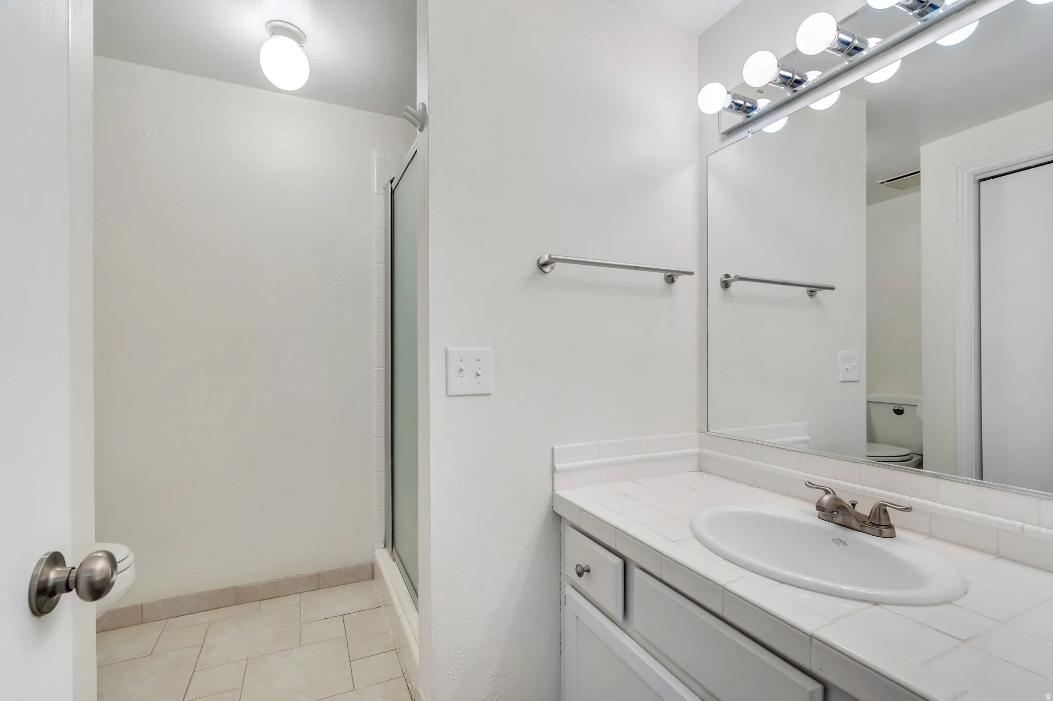 Full bathroom with vanity and a shower stall